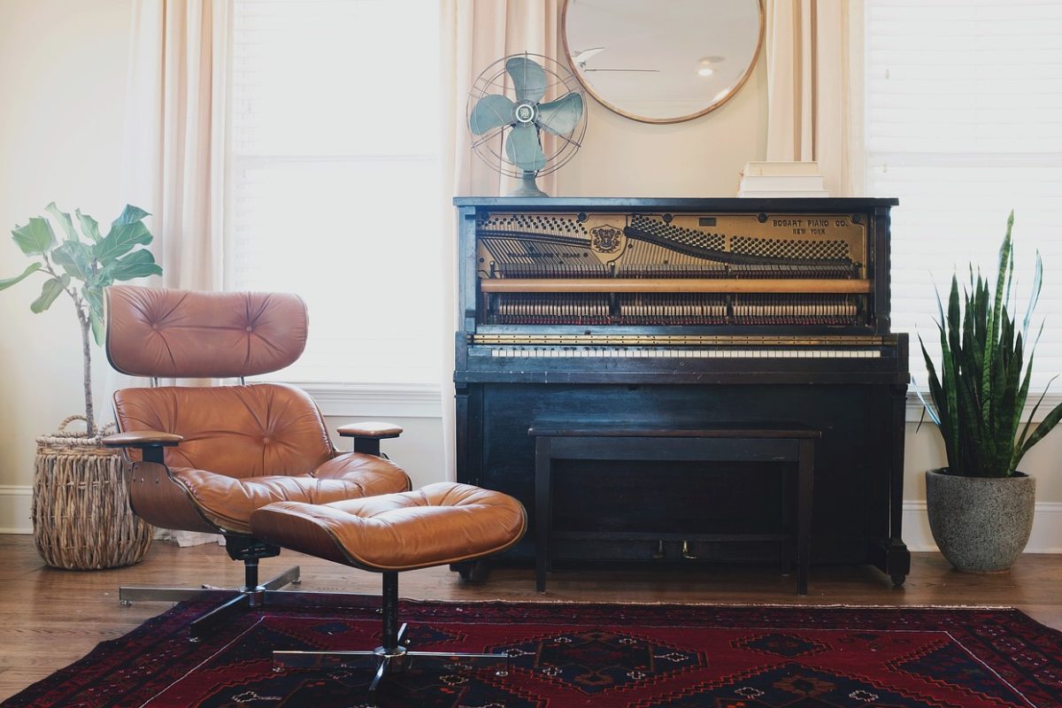 Un piano droit dans un salon, prêt pour une leçon