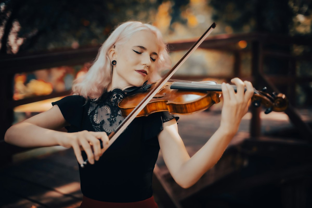 Une violoniste joue debout, l'archet en main